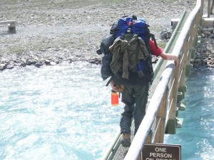 A student crosses one of the many bridges on the way to Berg Lake. 