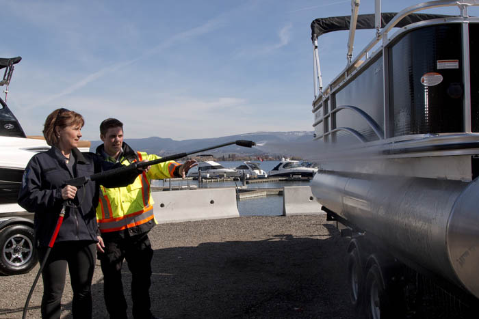 BC Premier Christy Clark pitches in, pressure-washing watercraft to dislodge any mollusc hitchhikers.