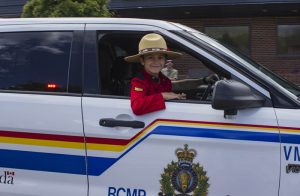 Brayden Woroshelo certainly looks the part, as he takes in the parade from a unique perspective next to his dad RCMP Sergeant Darren Woroshelo. / EVAN MATTHEWS