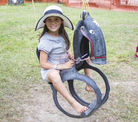 Photo: Maddi Pickerl Eliana Huzovicova rides the horse swing in the kid’s area on Sunday.