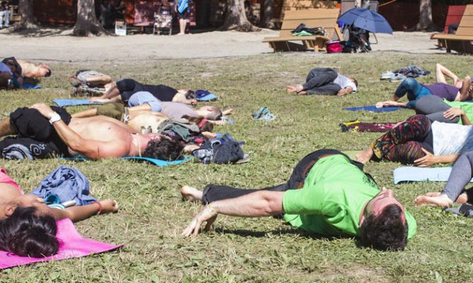 Photo: Evan Matthews — Over 50 people gathered near the Main Stage on Sunday morning to do some Bees Knees Yoga, with Donalda Beeson.